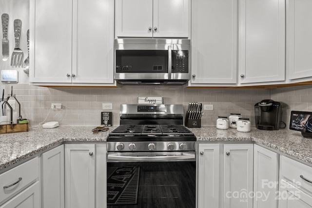 7172 Indigo Way, Denver, NC 28037 - kitchen featuring appliances with stainless steel finishes, white cabinets, decorative backsplash, and light stone counters