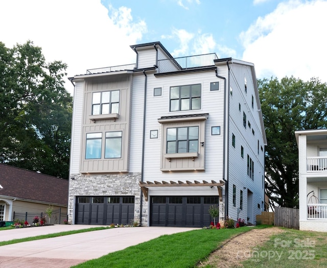 view of front of house featuring a garage, fence, stone siding, and driveway