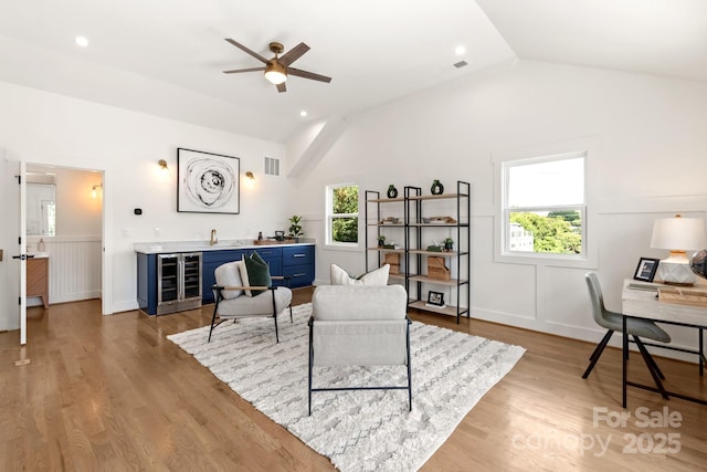 living area with a ceiling fan, visible vents, lofted ceiling, indoor wet bar, and wine cooler