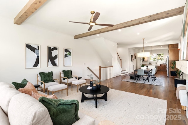 living area featuring beamed ceiling, dark wood finished floors, recessed lighting, ceiling fan, and stairs