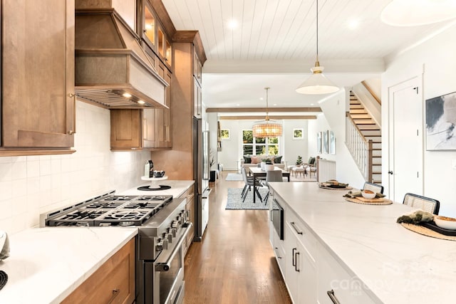 kitchen featuring brown cabinets, appliances with stainless steel finishes, wood finished floors, and custom range hood