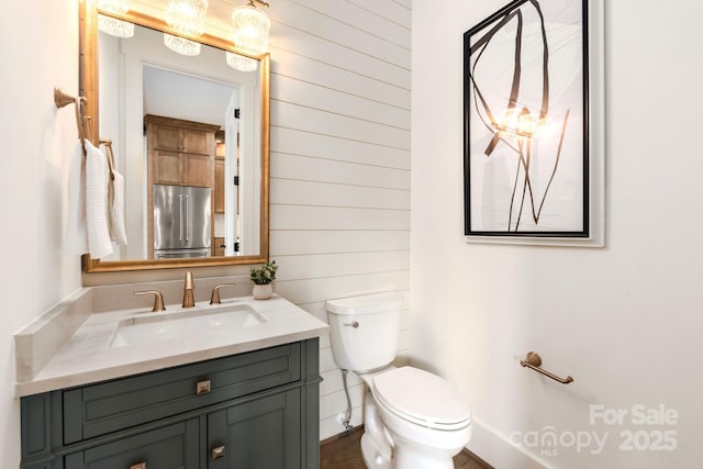 half bath featuring toilet and vanity