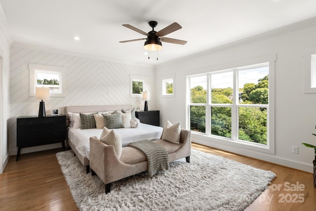 bedroom with a ceiling fan, recessed lighting, crown molding, light wood finished floors, and baseboards