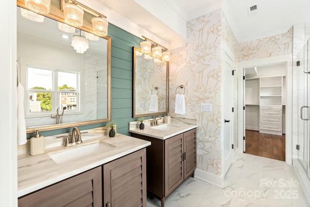 full bath featuring a sink, two vanities, marble finish floor, and a stall shower