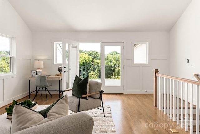 living room featuring lofted ceiling, plenty of natural light, and light wood-style floors