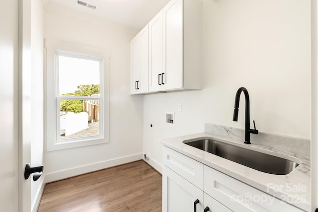laundry room featuring visible vents, hookup for an electric dryer, cabinet space, a sink, and washer hookup