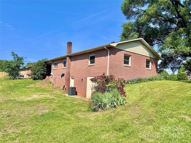 817 Dudley Shoals Rd, Granite Falls, NC 28630 - view of property exterior featuring brick siding, a lawn, central AC, and a chimney