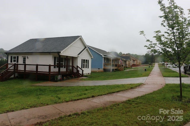 view of home's exterior with a wooden deck, a lawn, and a shingled roof