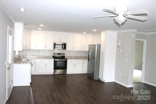 kitchen with a sink, tasteful backsplash, appliances with stainless steel finishes, and white cabinetry