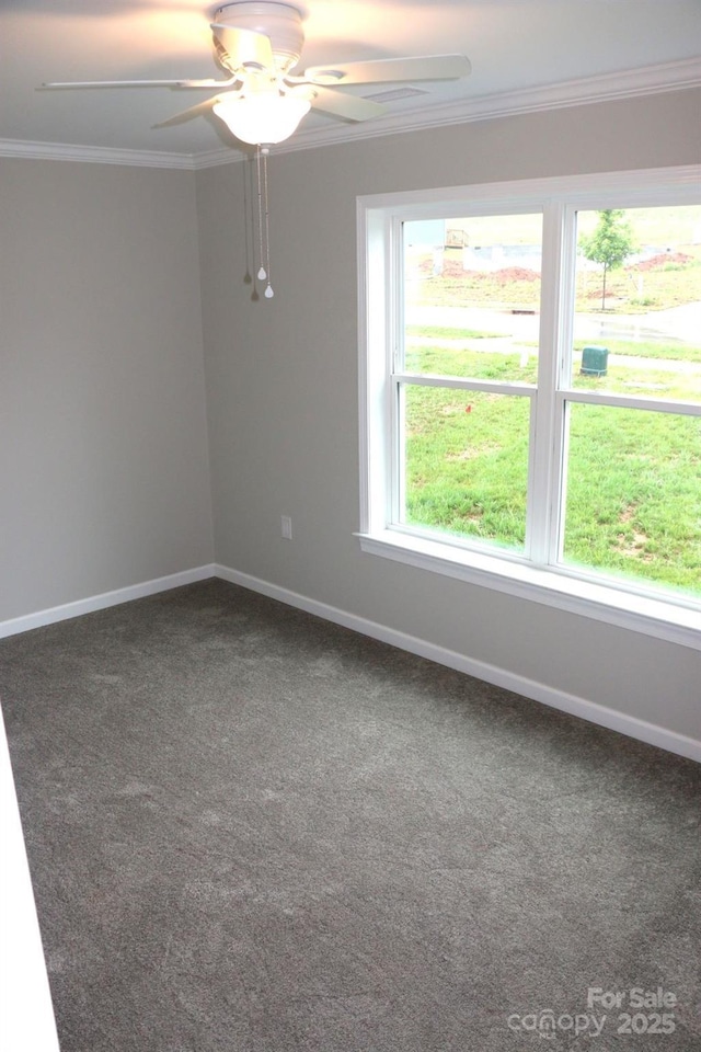 carpeted spare room featuring a wealth of natural light, baseboards, crown molding, and a ceiling fan