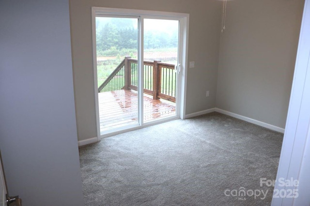 carpeted spare room featuring baseboards