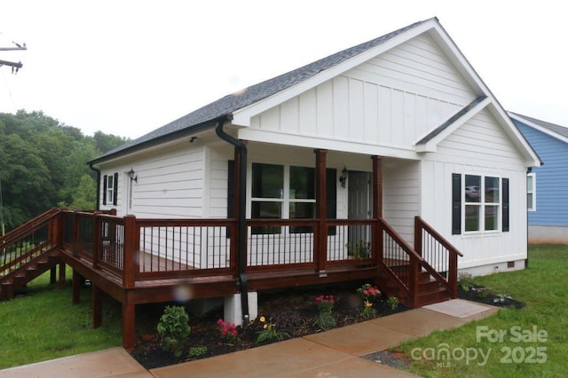 exterior space featuring crawl space, a front lawn, covered porch, and a shingled roof