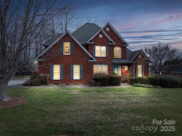 traditional home with brick siding and a lawn