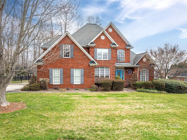 view of front of home featuring a front lawn, brick siding, and a shingled roof