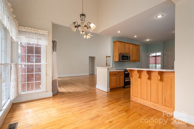 kitchen with visible vents, a chandelier, a breakfast bar, light countertops, and stainless steel appliances