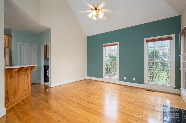 unfurnished living room with a healthy amount of sunlight, baseboards, and light wood finished floors