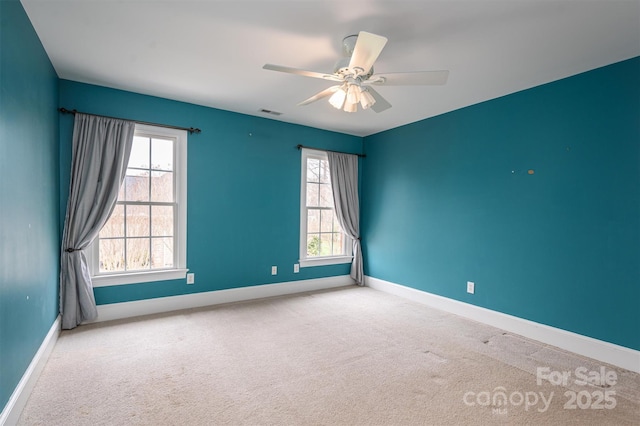 empty room with a wealth of natural light, baseboards, and carpet floors