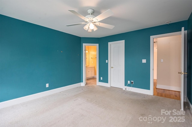 unfurnished bedroom with ensuite bath, a ceiling fan, baseboards, and carpet floors