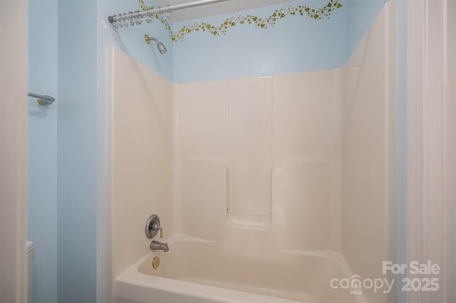 bathroom featuring toilet and shower / bathing tub combination