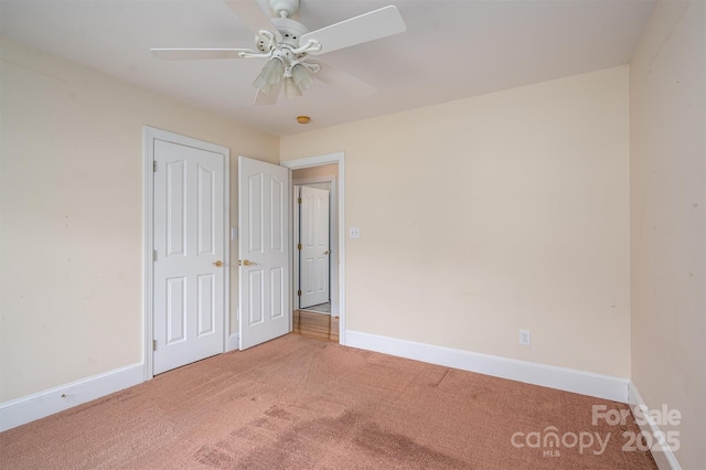 unfurnished bedroom featuring a closet, ceiling fan, baseboards, and carpet