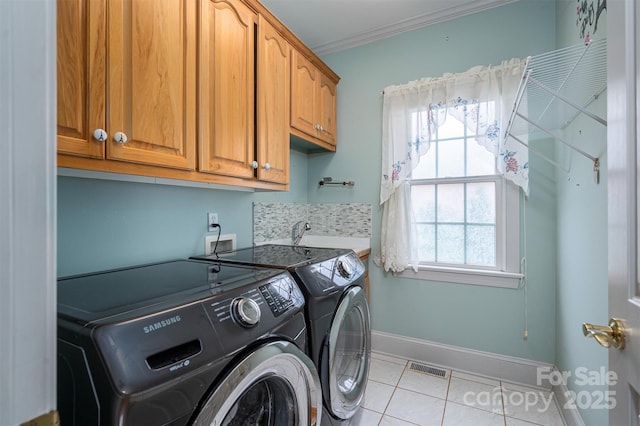 washroom with visible vents, light tile patterned flooring, cabinet space, a sink, and washer and dryer