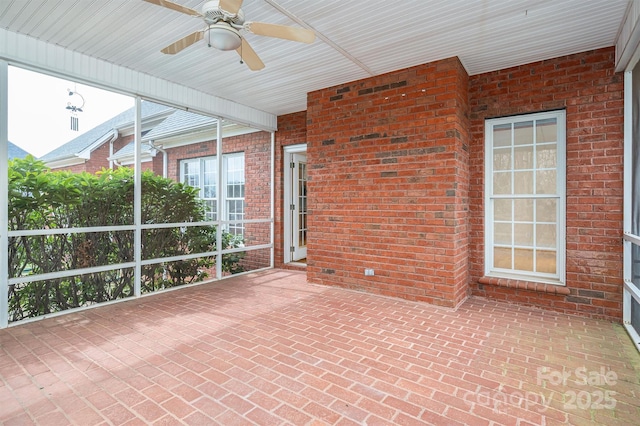 unfurnished sunroom featuring a ceiling fan