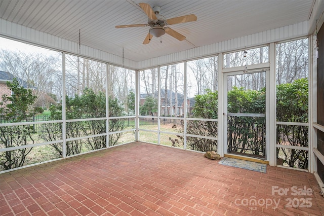 unfurnished sunroom with ceiling fan