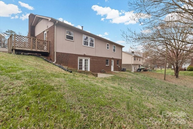 rear view of property featuring a yard, french doors, brick siding, and a chimney