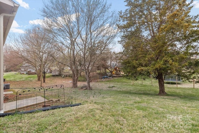 view of yard featuring central AC and a trampoline