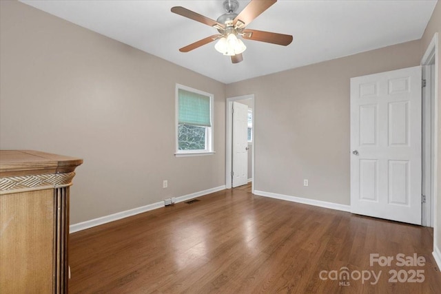 unfurnished bedroom featuring visible vents, wood finished floors, baseboards, and ceiling fan