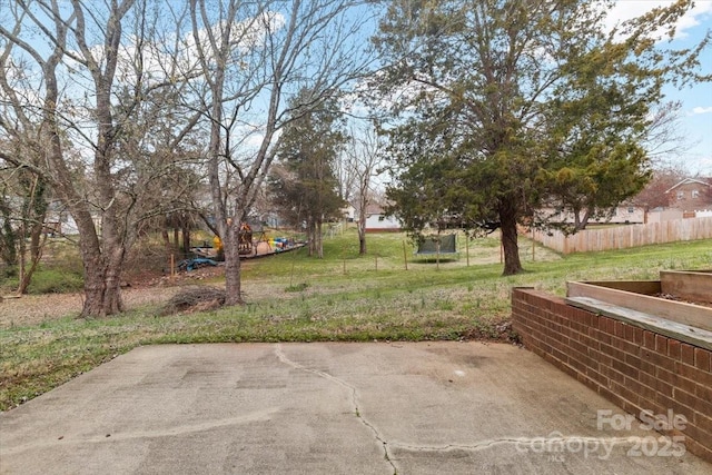 view of yard featuring a patio area, a trampoline, and fence