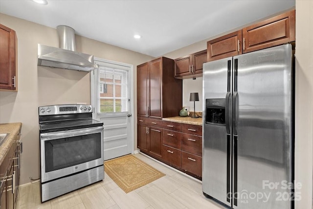 kitchen featuring recessed lighting, stainless steel appliances, wall chimney exhaust hood, and light countertops