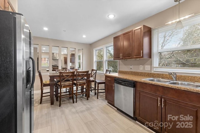 kitchen featuring recessed lighting, a sink, hanging light fixtures, light countertops, and appliances with stainless steel finishes