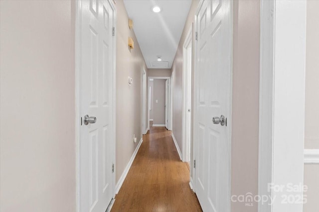 hallway featuring recessed lighting, wood finished floors, and baseboards