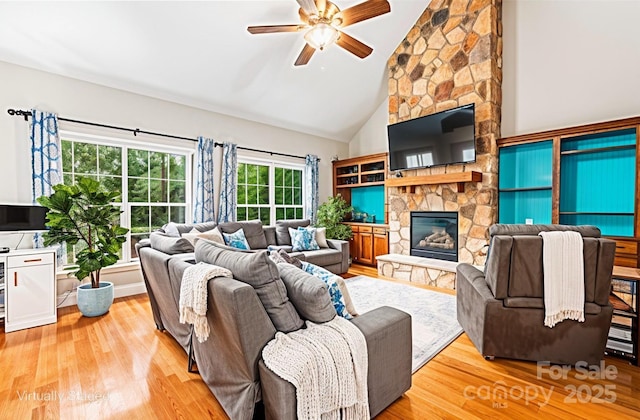 4858 Sagittarius Cir, Denver, NC 28037 - living room with a ceiling fan, a stone fireplace, light wood-style flooring, and high vaulted ceiling