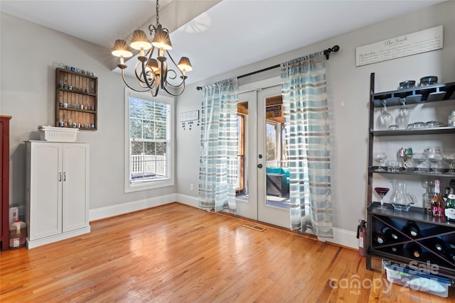 4858 Sagittarius Cir, Denver, NC 28037 - unfurnished dining area with french doors, a chandelier, light wood finished floors, and baseboards