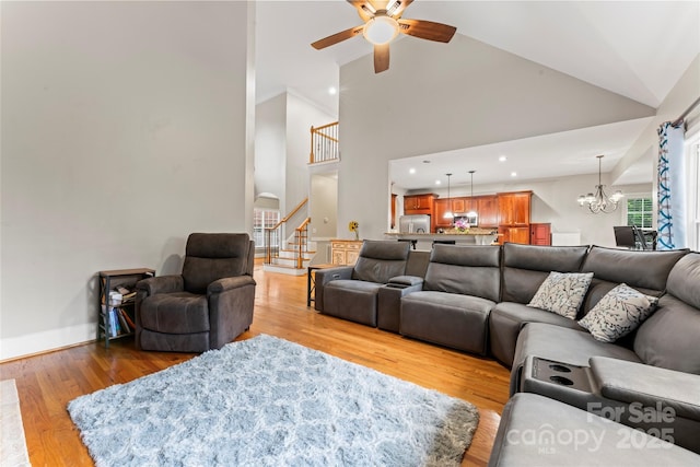 4858 Sagittarius Cir, Denver, NC 28037 - living room featuring stairs, high vaulted ceiling, ceiling fan, a chandelier, and light wood finished floors