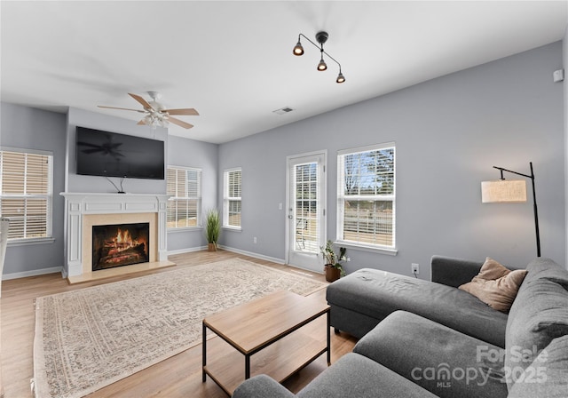 2259 Crosscut Dr, Charlotte, NC 28214 - living room featuring wood finished floors, ceiling fan, a lit fireplace, and baseboards