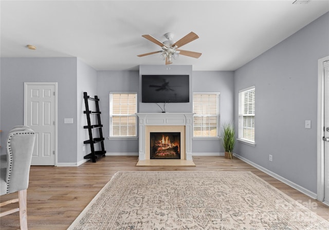 2259 Crosscut Dr, Charlotte, NC 28214 - living area featuring ceiling fan, wood finished floors, a warm lit fireplace, and baseboards