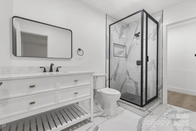 full bathroom featuring a marble finish shower, baseboards, toilet, marble finish floor, and vanity