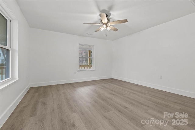 spare room featuring wood finished floors, baseboards, and ceiling fan