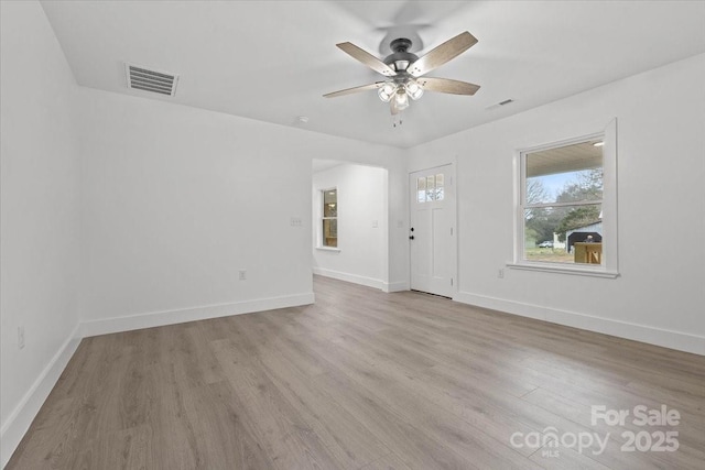 foyer entrance featuring baseboards, wood finished floors, visible vents, and ceiling fan