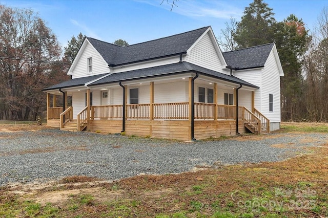 view of front of home with gravel driveway, a porch, and roof with shingles