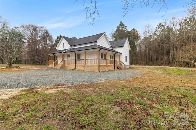 view of side of property featuring a porch and driveway