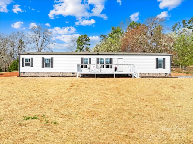 view of front of property with a wooden deck, a front lawn, and crawl space