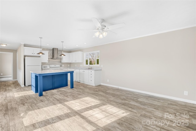 kitchen with white cabinetry, white appliances, wall chimney range hood, and crown molding