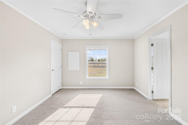 unfurnished room with ornamental molding, light colored carpet, baseboards, and ceiling fan