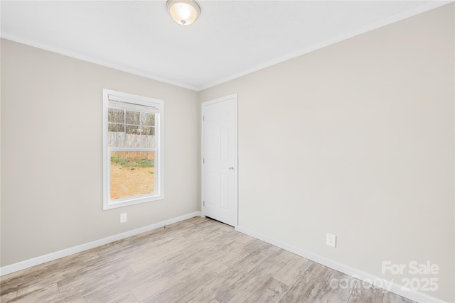 unfurnished room featuring light wood-type flooring, baseboards, and ornamental molding