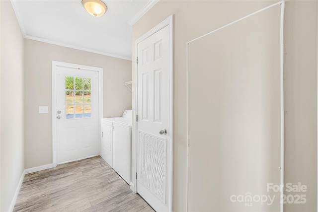 clothes washing area featuring baseboards, laundry area, light wood-style flooring, ornamental molding, and independent washer and dryer