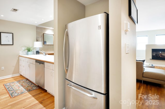 32 Broadway St Unit 330, Asheville, NC 28801 - kitchen featuring stainless steel appliances, light wood-type flooring, light countertops, a sink, and open floor plan